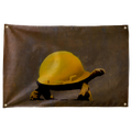 A tortoise wears an oversized yellow construction hard hat against brown-grey on this humorous horizontal Wall Rebel fabric wall flag.