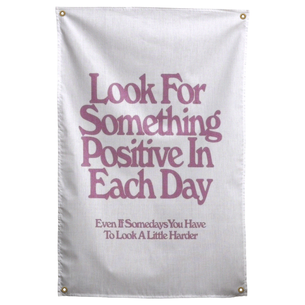 Muted pink Look For Something Positive In Each Day lettering stacks on white in this encouraging Wall Rebel fabric wall flag.