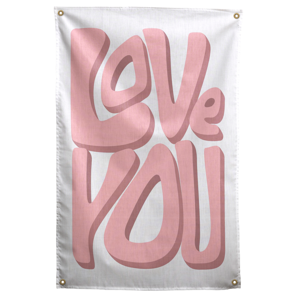 Large soft pink Love You lettering casts darker dimensional shadows on a pale background in this Wall Rebel fabric wall flag.