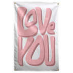Large soft pink Love You lettering casts darker dimensional shadows on a pale background in this Wall Rebel fabric wall flag.