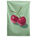 Two glossy pink cherries with angular highlights cast a long shadow across mint green on this Wall Rebel fabric wall flag.