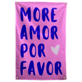 Deep purple MORE AMOR POR FAVOR lettering and a white heart stand out against bright pink on a Wall Rebel fabric wall flag.