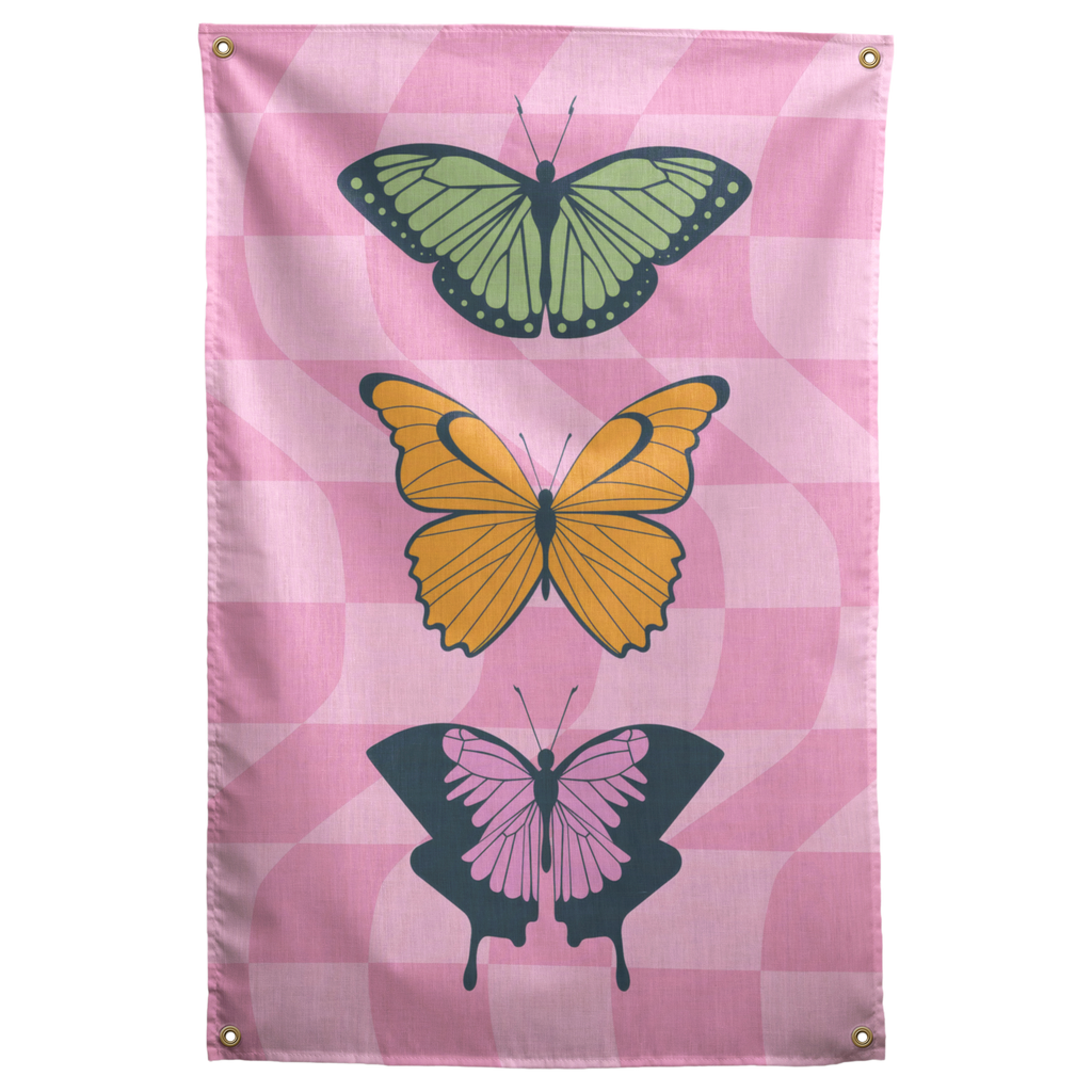 Three green, yellow and pink butterflies stack over a pastel pink checkerboard on this colourful Wall Rebel fabric wall flag.