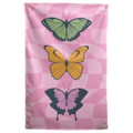 Three green, yellow and pink butterflies stack over a pastel pink checkerboard on this colourful Wall Rebel fabric wall flag.