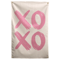 Broad pink brush marks spell XOXO across a pale cream background in this loose, playful Wall Rebel fabric wall flag.