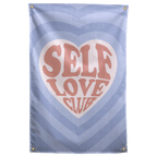Self Love Club lettering fills a pale heart within layers of blue heart shapes on this patterned Wall Rebel fabric wall flag.