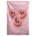 Three orange smiley faces show different moods over flowing pink stripes on this playful patterned Wall Rebel fabric wall flag.