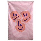 Three orange smiley faces show different moods over flowing pink stripes on this playful patterned Wall Rebel fabric wall flag.