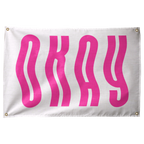 Tall bright pink OKAY letters ripple in vertical waves across a pale horizontal background on a Wall Rebel fabric wall flag.