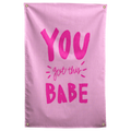 Bright pink You Got This Babe lettering with small accent strokes fills a pale pink Wall Rebel fabric wall flag.